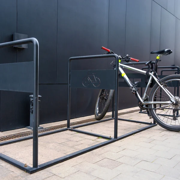 Rower zaparkowany w stojaku rowerowym przy budynku - zewnętrzne stojaki rowerowe