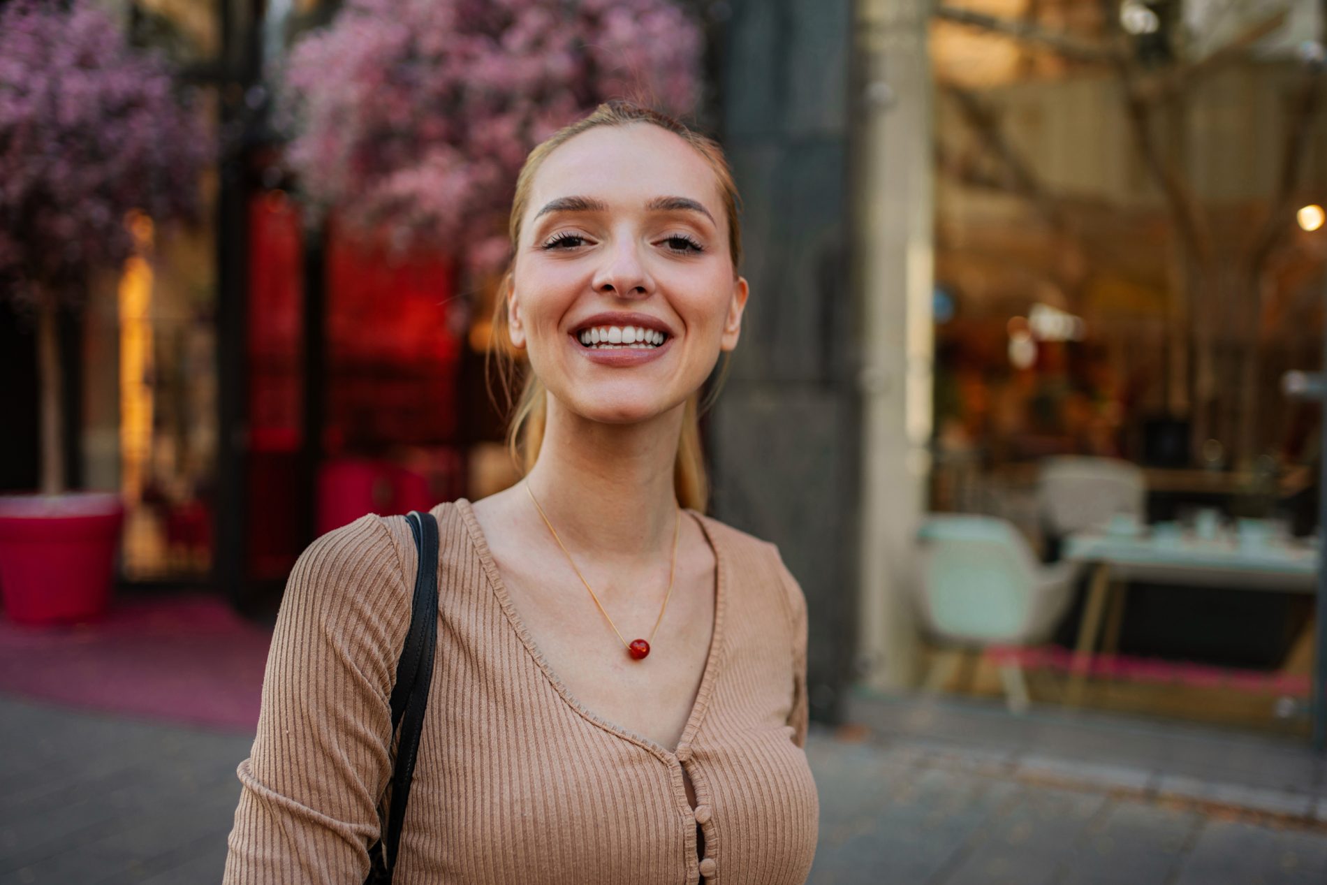 Obraz przedstawiający uśmiechniętą kobietę w otoczeniu natury i miejskiego zgiełku